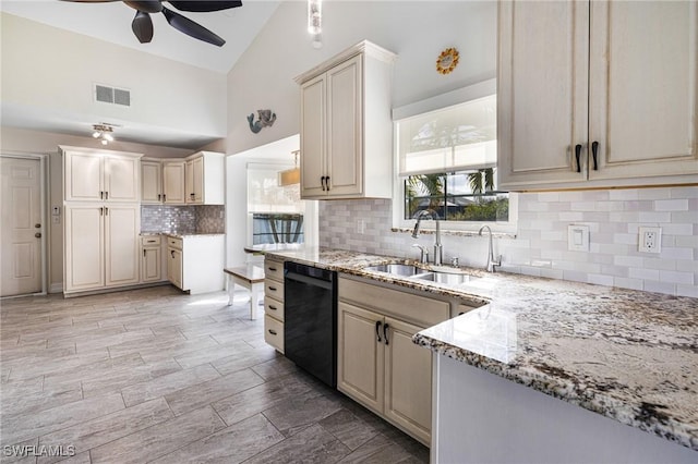 kitchen with sink, dishwasher, ceiling fan, light stone countertops, and cream cabinetry