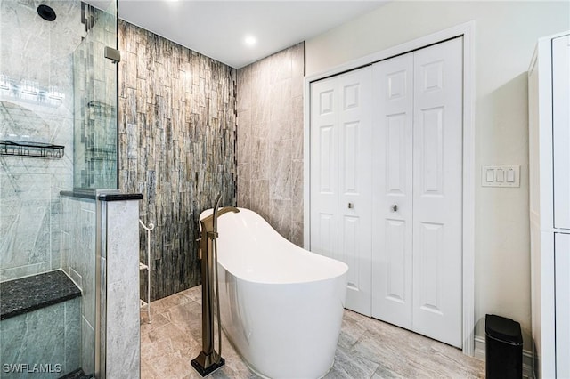 bathroom featuring separate shower and tub and tile walls