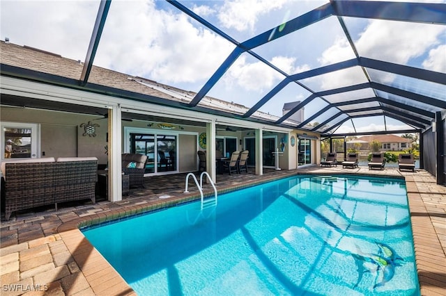 view of pool with outdoor lounge area, glass enclosure, and a patio area