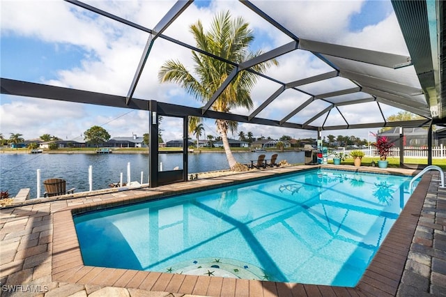 view of pool featuring a patio, glass enclosure, and a water view