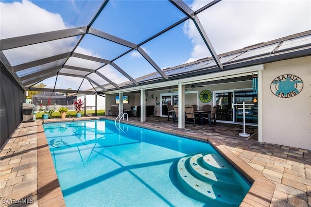 view of swimming pool featuring a lanai, a patio area, and ceiling fan