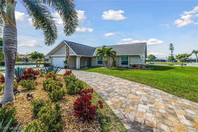 ranch-style home featuring a garage, a front yard, and a water view