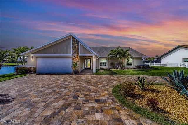 ranch-style home with a garage and a yard