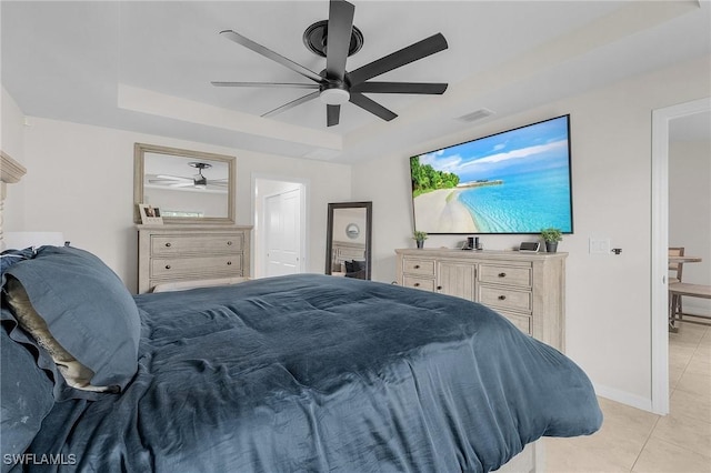 bedroom featuring a raised ceiling, light tile patterned floors, and ceiling fan