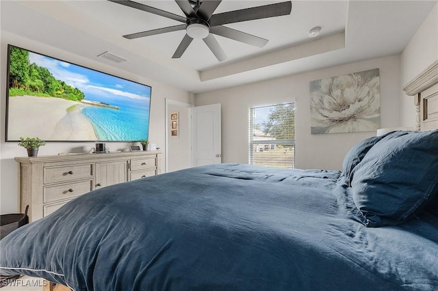 bedroom with a tray ceiling and ceiling fan