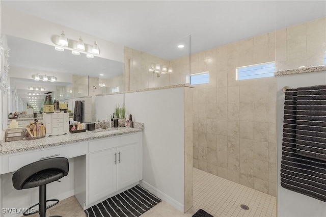 bathroom featuring vanity, tile patterned floors, and a tile shower