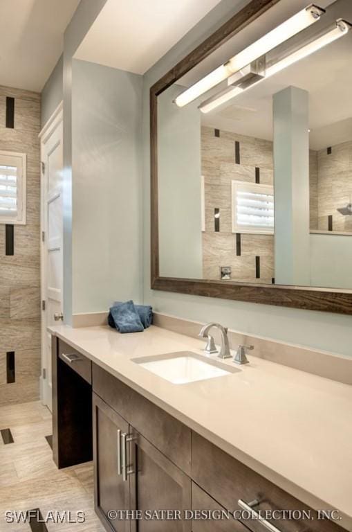 bathroom with vanity, a healthy amount of sunlight, and tile walls