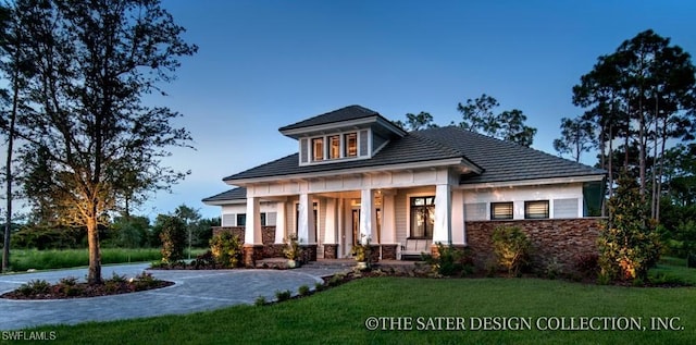 view of front of home featuring covered porch and a front lawn