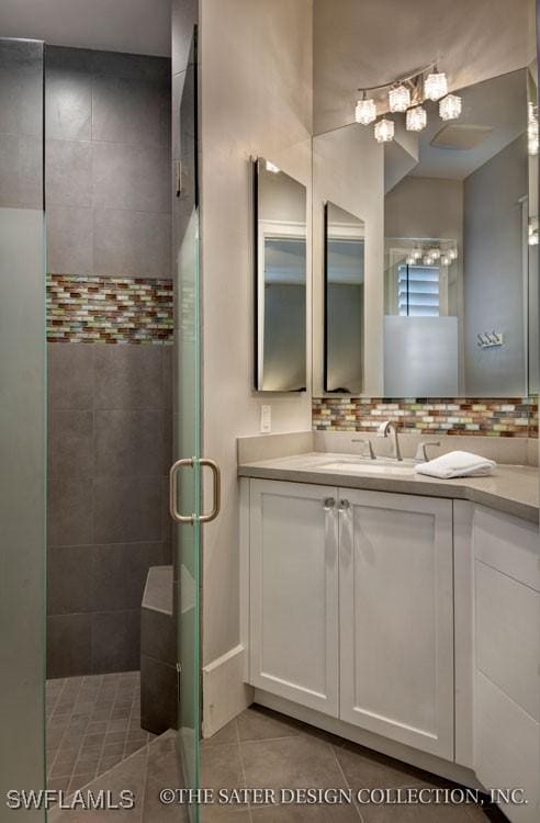 bathroom with vanity, a shower with shower door, and tile patterned floors