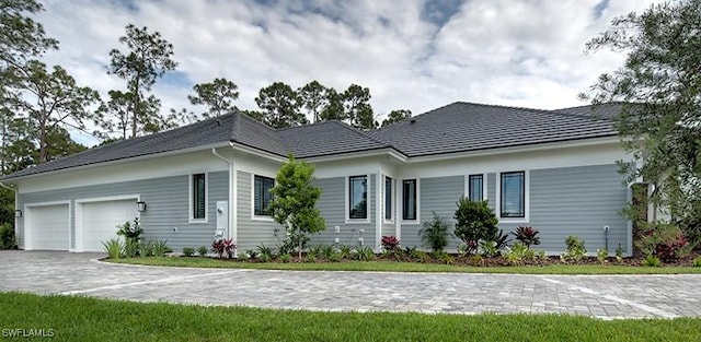 single story home featuring a garage and decorative driveway