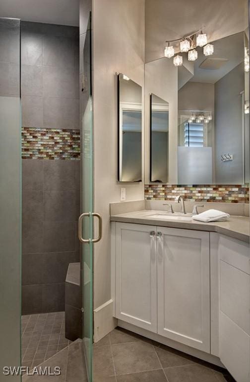 full bath featuring a shower stall, decorative backsplash, tile patterned flooring, and vanity