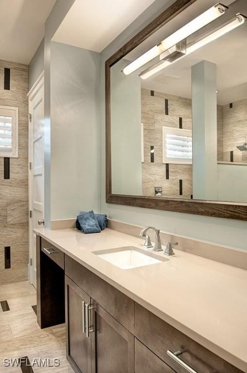 bathroom featuring tile walls, vanity, and walk in shower