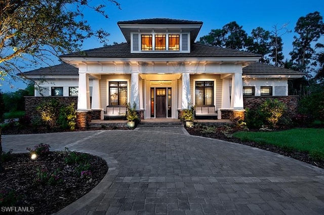 view of front of house with a porch and decorative driveway