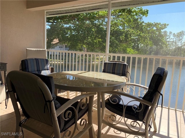 sunroom featuring a water view