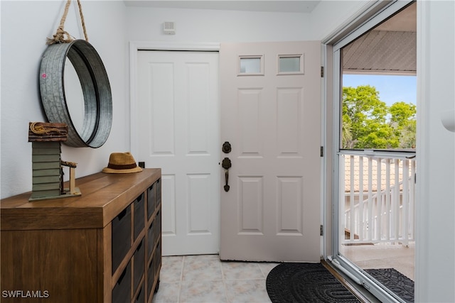 foyer with a wealth of natural light and light tile patterned flooring