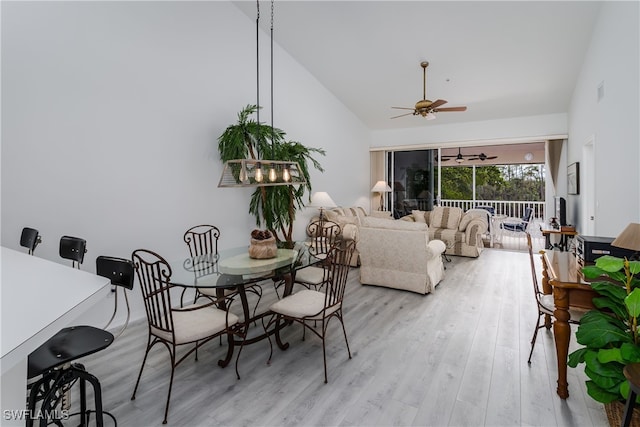 dining room with vaulted ceiling, ceiling fan, and light hardwood / wood-style flooring