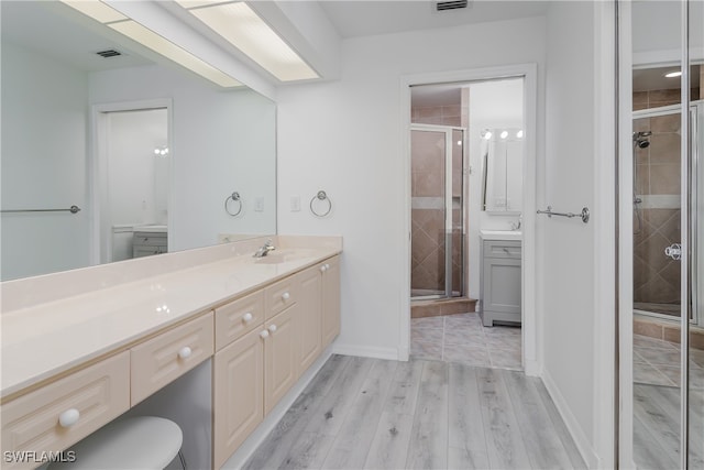 bathroom with walk in shower, vanity, and wood-type flooring