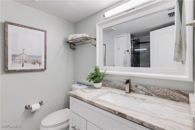 bathroom with a shower, vanity, and toilet