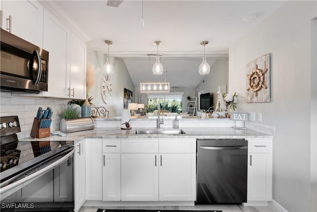 kitchen featuring white cabinets, appliances with stainless steel finishes, decorative backsplash, and lofted ceiling