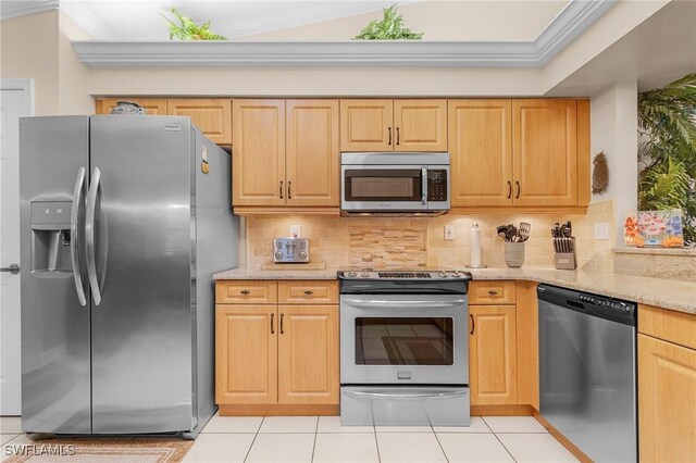 kitchen featuring light stone counters, backsplash, light tile patterned floors, and stainless steel appliances