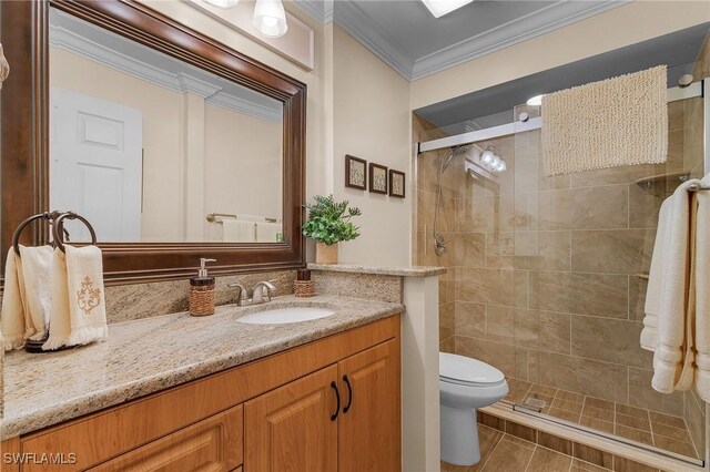 bathroom featuring toilet, walk in shower, crown molding, and vanity