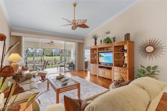 living room featuring crown molding, light hardwood / wood-style flooring, vaulted ceiling, and ceiling fan