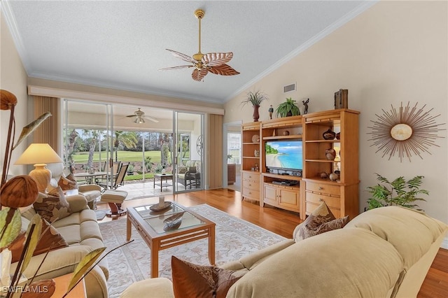 living room with lofted ceiling, visible vents, crown molding, a ceiling fan, and light wood-style floors