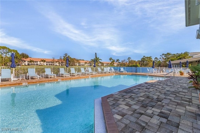 community pool featuring fence and a patio area