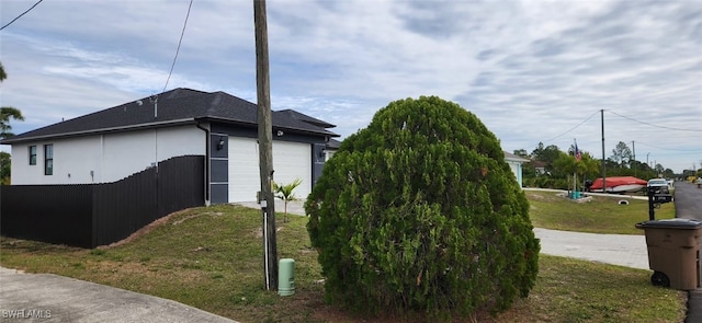 view of side of property with a garage and a lawn