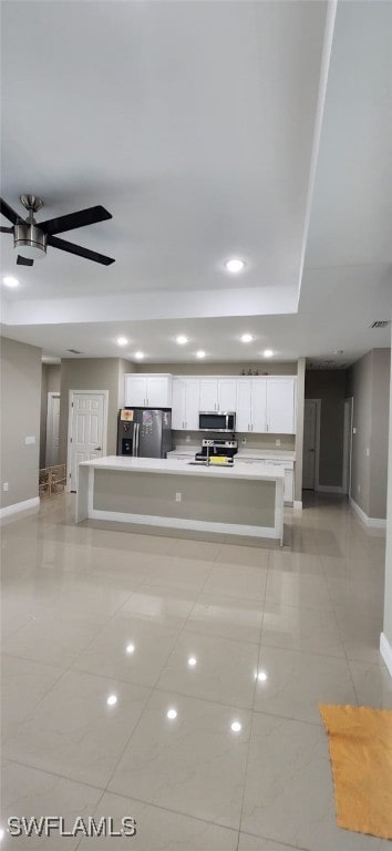 unfurnished living room featuring ceiling fan and light tile patterned floors