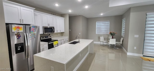 kitchen with white cabinets, appliances with stainless steel finishes, a kitchen island with sink, and sink