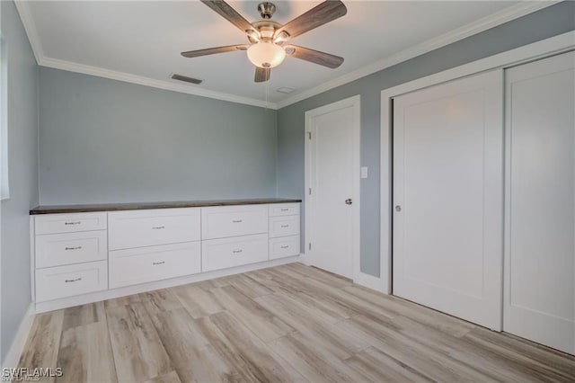 unfurnished bedroom featuring crown molding, a closet, ceiling fan, and light hardwood / wood-style flooring