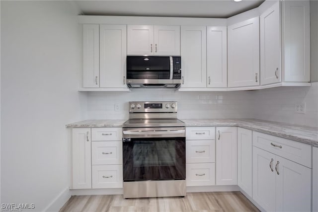 kitchen featuring tasteful backsplash, white cabinetry, appliances with stainless steel finishes, and light hardwood / wood-style floors