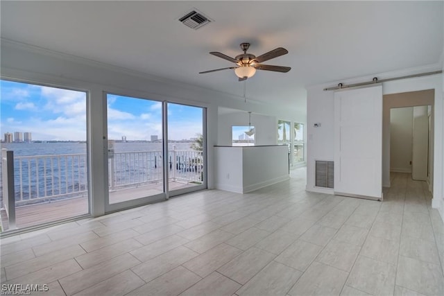 unfurnished room with crown molding, ceiling fan, and a barn door