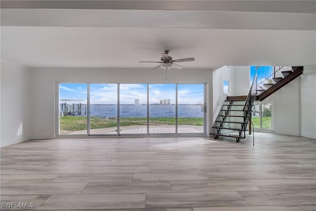 unfurnished living room with plenty of natural light, ceiling fan, and light hardwood / wood-style flooring