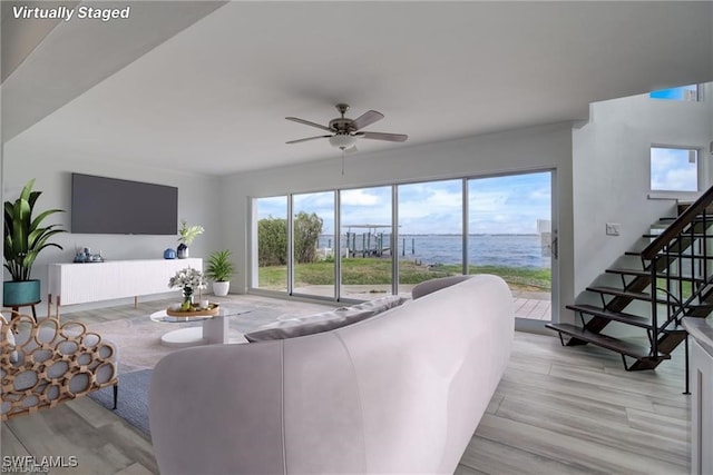 living room with light hardwood / wood-style floors and ceiling fan