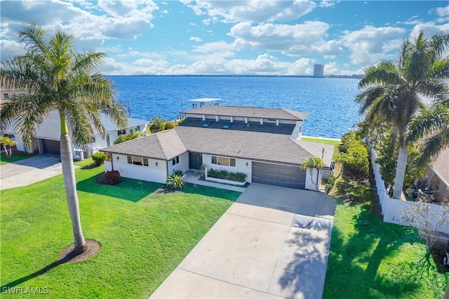 view of front of house with a water view, a garage, and a front lawn