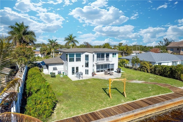 back of house featuring a balcony, a lawn, and a patio area