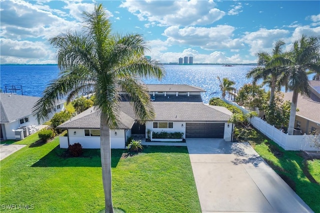 view of front of house with a water view, a garage, and a front lawn