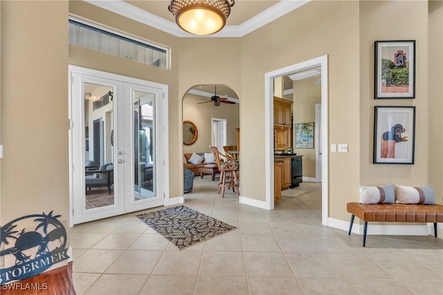 entryway featuring ceiling fan, light tile patterned floors, french doors, and ornamental molding