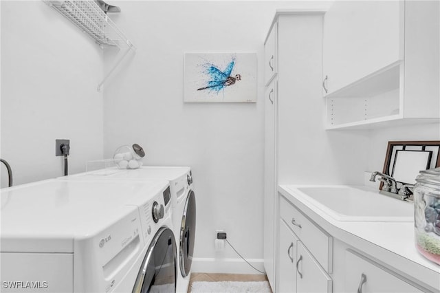 clothes washing area with cabinets, sink, and washing machine and clothes dryer