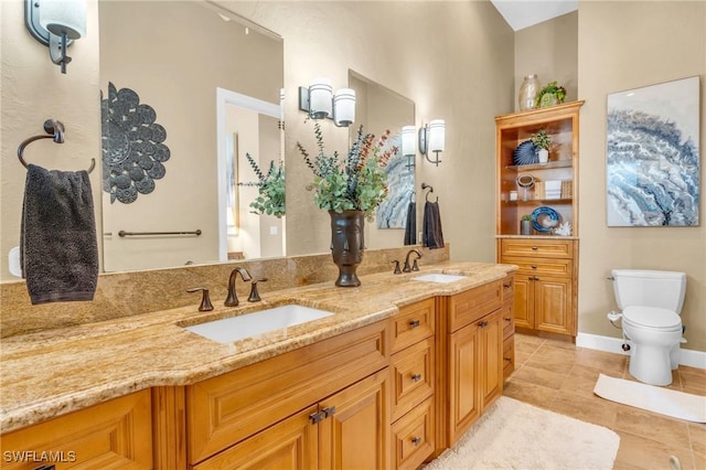 bathroom featuring toilet, vanity, and tile patterned flooring