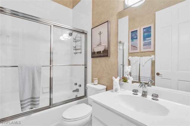 full bathroom featuring combined bath / shower with glass door, vanity, and toilet