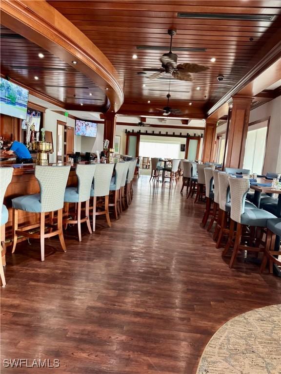 dining area with ceiling fan, dark wood-type flooring, and wooden ceiling