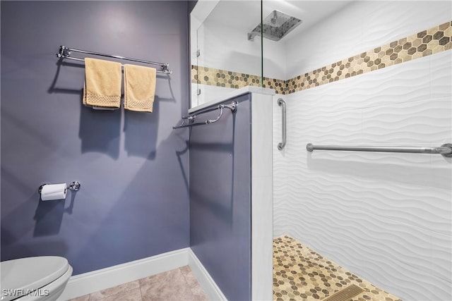 bathroom featuring toilet, a shower, and tile patterned flooring