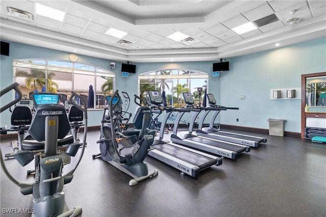 exercise room with a drop ceiling and a tray ceiling