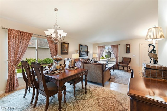 tiled dining room with a chandelier