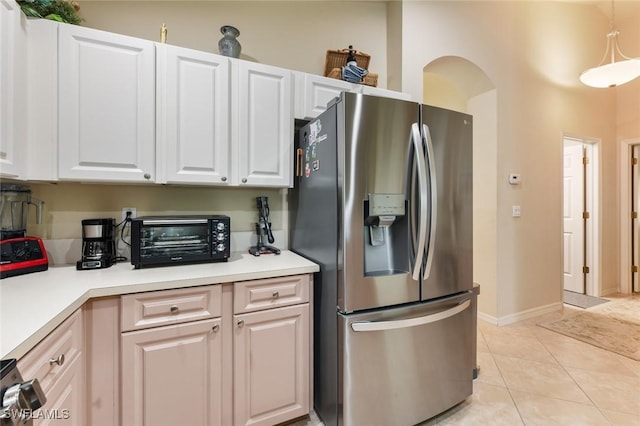 kitchen featuring stainless steel fridge with ice dispenser, white cabinetry, hanging light fixtures, and light tile patterned floors