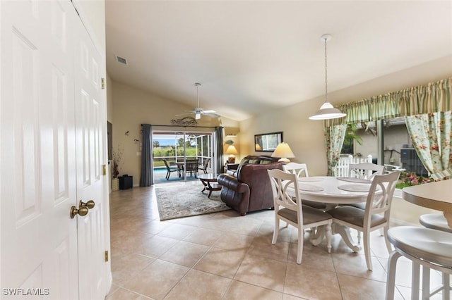 dining area with ceiling fan, light tile patterned floors, and lofted ceiling