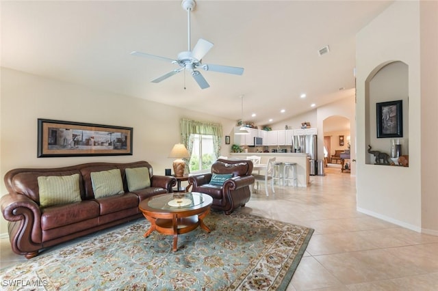 tiled living room with ceiling fan and vaulted ceiling